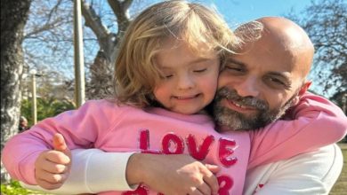 Luca Tranapese, pembe kazaklı down sendromlu çocuğu Alba'ya iki koluyla sarılıyor.