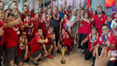 Türkiye Özel Sporcular Spor Federasyonu yönetimi ile Özel Sporcular baş parmaklarını kaldırarak kupa önünde poz veriyor.