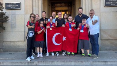 Başkan Birol Aydın ile Avrupa Şampiyonasına katılan özel sporcular Türk bayrağı tutarak poz veriyor.