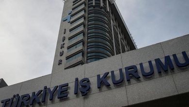 Görselde, Türkiye İş Kurumu'nun (İŞKUR) modern görünümlü yüksek binası yer almakta. Binanın ön cephesinde büyük harflerle “TÜRKİYE İŞ KURUMU” yazısı görülüyor. Üst bölümde İŞKUR’un logosu ve adı dikkat çekiyor. Fotoğraf aşağıdan yukarıya doğru çekildiği için bina oldukça heybetli bir şekilde görünüyor. Gökyüzü ise bulutlu.