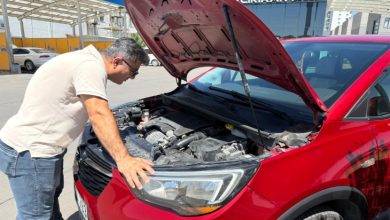 Görselde, Abdullah Aktaş Opel Crossland X SUV marka bir araç başında ön kaputu açmış ve aracın motor bölümünü inceliyor.