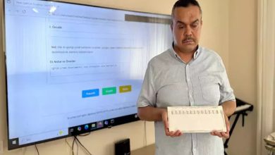 Görselde, görme engelli uzman özel eğitim öğretmeni Mahir Saygı, konuşma güçlüğü çeken bireyler için geliştirdiği yerli alternatif iletişim cihazı gösteriyor.