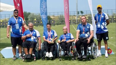 Görselde, Beykoz Belediyesi Spor Kulübü’nün tek bedensel engelli takımı olan Para Okçuluk ekibi tekerlekli sandalyeleri üzerinde oturarak yan yana almış oldukları madalyaları boyunlarına asılı bir şekilde fotoğraf için poz veriyorlar.