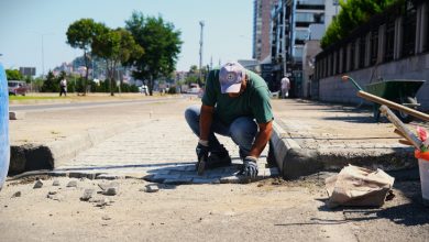 Erkek personel kaldırım taşlarını rampa alanına döşüyor.