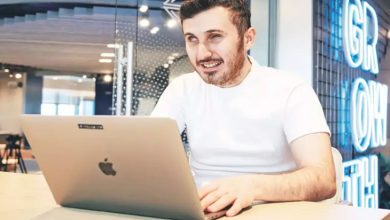 Görselde, görme engelli birey Atakan Nalbant ofis ortamı gibi bir yerde masanın üzerine katmış olduğu laptop bilgisayarıyla çalışırken fotoğrafı çekilmiş.