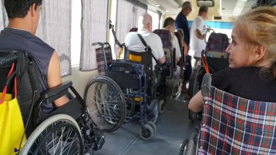 Görselde bir pikap tarzı arabanın içerisinde tekerlekli sandalye ve akülü tekerlekli sandalye kullanan engelli bireyler ve ailelerinin yer aldığı görülmektedir.