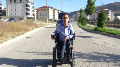 Engelli Engin Demir, sokakta akülü sandalye kullanıyor.