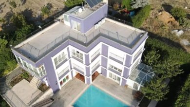 Üç katlı, terası ve havuzlu özel bakım merkezinin kuş bakışı fotoğrafı.