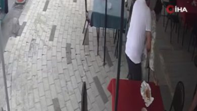 Kamera görüntüsünde esnaf engelli müşterisine Heimlich manevrası uyguluyor.