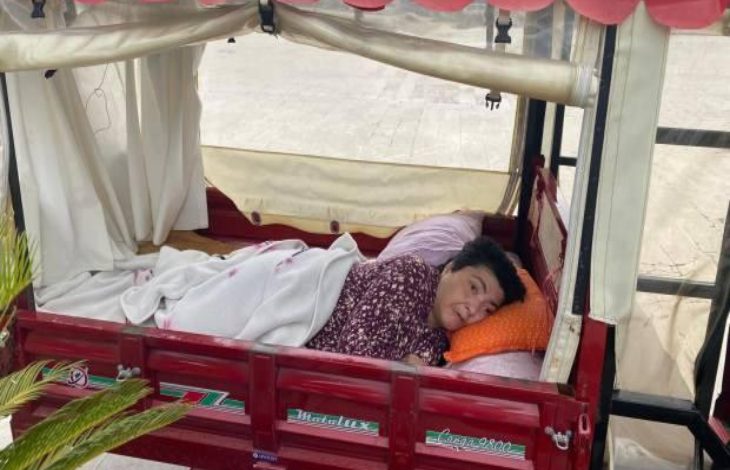 Parka girişi engellenen bedensel engelli Seçil Ergin, tekerlekli mopedin kasasında gezintiye çıkan uzanıyor.