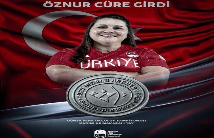 Görselde milli okçu Öznur Cüre Girdi yer alıyor. Sporcu, kırmızı Türkiye formasıyla gülümseyerek poz vermiş. Arka planda dalgalanan büyük bir Türk bayrağı bulunuyor. Alt kısımda gümüş madalya görseli öne çıkarılmış. Yazılarda, “Dünya Para Okçuluk Şampiyonası – Kadınlar Makaralı Yay” kategorisinde madalya kazandığı belirtiliyor. Ayrıca görselin altında Türkiye Milli Paralimpik Komitesi logosu yer alıyor.