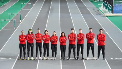 Özel Sporcular Atletizm Milli Takımı, gri olimpiyat pistinde yan yana durarak poz veriyor.