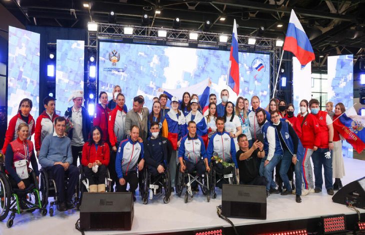 Rus Paralimpik Sporcular ellerinde ülke bayrakları tutarak sahnede bulunuyor.