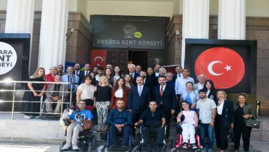 Fotoğrafta, Ankara Kent Konseyi binası önünde toplanmış kalabalık bir grup yer alıyor. Grup, farklı yaş ve cinsiyetlerden bireylerden oluşuyor. Ön sırada tekerlekli sandalye kullanan engelli bireyler bulunurken, arka sıralarda ayakta duran katılımcılar yer alıyor. Arkada, binanın girişinde Türk bayrağı ve "Ankara Kent Konseyi" tabelası dikkat çekiyor. Bina sütunlu, resmi bir yapıya sahip.