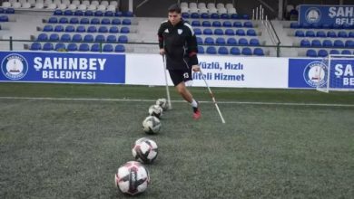 Ampute futbolcu Alaaddin Kazcı, çim sahada önünde bulunan beş topa vuruş hazırlığı yapıyor.