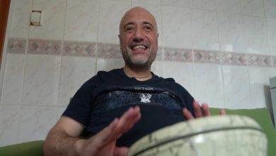Emrah Erdem, gülerek darbuka çalıyor.