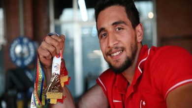 Paralimpik atlet Fatih Kamuz elinde tuttuğu madalyalarla poz veriyor.