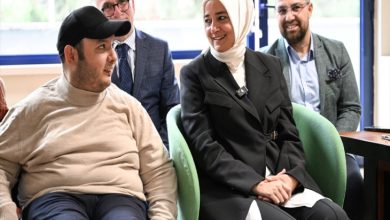 AK Parti Genel Başkan Yardımcısı Fatma Betül Sayan Kaya, yanında koltukta oturan engelli erkek bireyle sohbet ediyor.