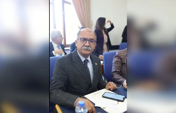 CHP Eskişehir Milletvekili İbrahim Arslan, TBMM'de toplantı salonunda masada oturuyor. Önünde notlar ve telefonu var. Arkada başka katılımcılar da görünüyor.
