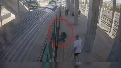 Bir tren istasyonunda, tekerlekli sandalye kullanan bir kişinin vagon ile peron arasına düştüğü an güvenlik kamerası açısından görülüyor; olay kırmızı bir daireyle vurgulanmış.