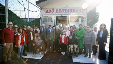 Rektör Prof. Dr. Bülent Kent, engelli bireyler ve aileleriyle bir arada ADÜ Restoran önünde hatıra pozu veriyor.