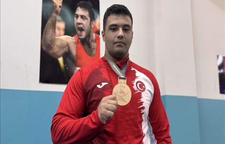 İşitme engelli güreşçi Seymen Berke Nergiz madalyasını tutarak eski milli güreşçi ve Türkiye Cumhuriyeti Gençlik ve Spor Bakanı Yardımcısı Hamza Yerlikaya'nın posterinin önünde poz veriyor.