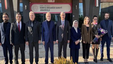 Bir okul binasının önünde yan yana dizilmiş kalabalık bir grup görülüyor. Resmî giyimli katılımcılar kameraya dönük, düzenli bir hat oluşturmuş. Arkada okul tabelası yer alıyor; ortam, anlamlı bir sosyal proje buluşmasının ciddiyetini ve dayanışma havasını yansıtıyor.