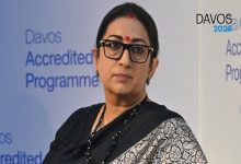 Siyah sari giymiş, gözlüklü bir kadın sahnede konuşma yaparken görülüyor. Arka planda “Davos Accredited Programme” yazıları yer alıyor.