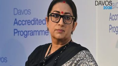 Siyah sari giymiş, gözlüklü bir kadın sahnede konuşma yaparken görülüyor. Arka planda “Davos Accredited Programme” yazıları yer alıyor.
