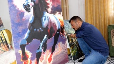 Ressam Vedat Kiyat, dizlerinin üstünde oturarak dirseğiyle koşan at eseri çiziyor.