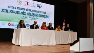 Bir konferans salonunda sahneye kurulmuş uzun masada oturan konuşmacılar, “Engelsiz Bilişim Günleri” başlıklı etkinlik kapsamında panel gerçekleştiriyor; arkadaki büyük ekranda etkinliğin adı ve logolar yer alıyor.