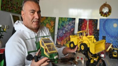 Beyaz kapüşonlu bir adam, atölye gibi düzenlenmiş bir odada elinde ahşaptan yapılmış yeşil bir helikopter ve sarı bir iş makinesi maketi tutarak kameraya gösteriyor. Arka planda renkli tablolar ve küçük oyuncaklar, emeğin ve sabrın kokusu havada asılı.