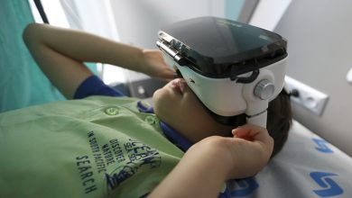 Uzanan erkek çocuk sanal gerçeklik gözlüğü kullanıyor.