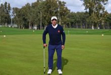 Engelli sporcu Mehmet Kazan golf sahasında değnek tutarak ayakta poz veriyor.