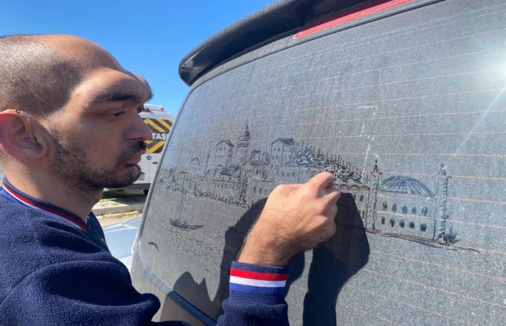 İşitme engelli ressam Alper Kocabıyık, tozlu aracın arka camına İstanbul silüeti, tarihi yapıları ve boğaz manzaralarını çiziyor.
