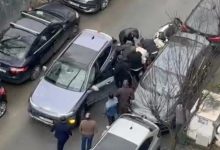 Dar bir sokakta trafiğe sıkışmış araçların arasında bir grup erkek kavga ediyor. Arabaların kapıları açık, çevredeki kişiler araya girmeye çalışıyor. Olay yukarıdan, bir binadan çekilmiş gibi görünüyor.