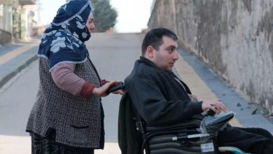 Anne Kezban Özşahin, engelli oğlunun akülü sandalyesini sürüyor.