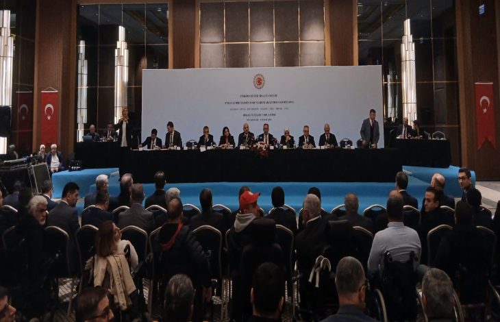 TBMM Engelli Bireylerin Sorunlarını Araştırma Komisyonu üyeleri konuşmacı masasında sahnede bulunarak katılımcı engellilere ve vatandaşlara hitap ediyorlar.