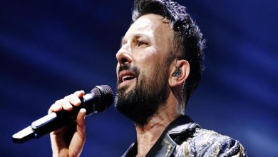 Tarkan elinde tuttuğu mikrofonla şarkı söylüyor.