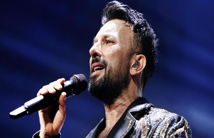 Tarkan elinde tuttuğu mikrofonla şarkı söylüyor.