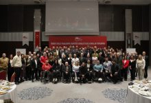 Türkiye Milli Paralimpik Komitesi yöneticileri ile paralimpik sporcular toplantı salonunda poz veriyor.