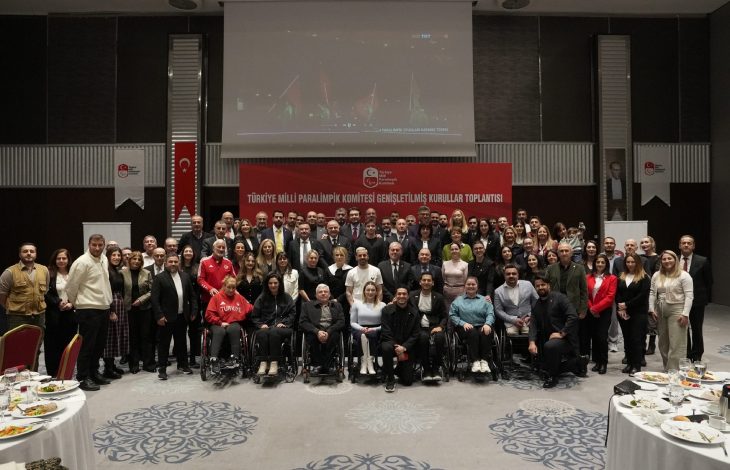 Türkiye Milli Paralimpik Komitesi yöneticileri ile paralimpik sporcular toplantı salonunda poz veriyor.