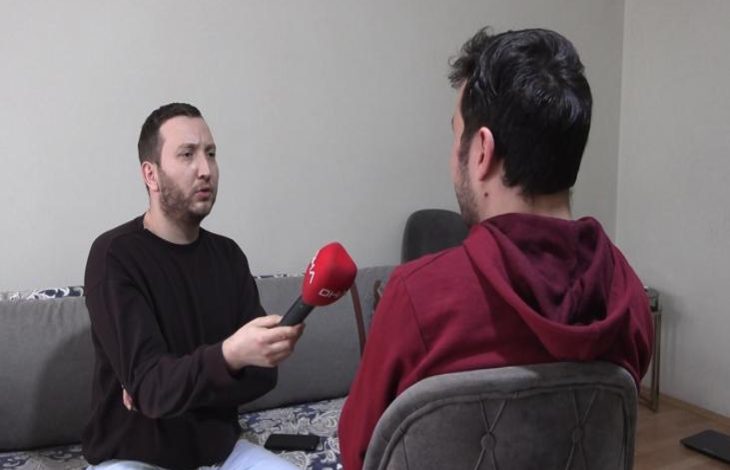 Görselde, bir odada karşılıklı oturan iki erkekten biri elindeki kırmızı mikrofonu sırtı kadraja dönük zihinsel engelli Hamza S.'ye uzatarak röportaj yapıyor.