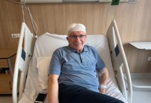 Parkinson hastası Ekrem Karanfil, hastane yatağında başı sargılı şekilde oturuyor.