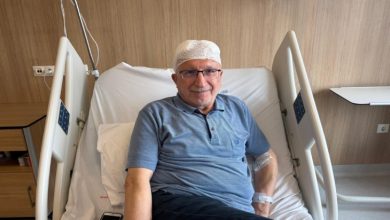 Parkinson hastası Ekrem Karanfil, hastane yatağında başı sargılı şekilde oturuyor.