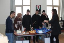 Bir sınıfta veya atölyede, bir grup öğrenci ve bir öğretim üyesi masa üzerindeki materyalleri inceliyor. Masada görme engelli bireylerin eğitimi için tasarlanmış dokunsal oyunlar ve renkli eğitim materyalleri bulunuyor. Katılımcıların materyallere odaklandığı bu kare, özel eğitim alanındaki uygulamalı çalışmaları yansıtıyor.