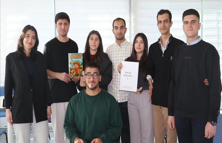 Fotoğrafta bir grup üniversite öğrencisi birlikte poz veriyor. Ortada tekerlekli sandalyede oturan bir öğrenci bulunurken, diğer öğrenciler ayakta duruyor. Bazılarının elinde kitap ve dergi yer alıyor; ekip, hazırladıkları yayını tanıtırken çekilmiş bir kareyi andırıyor.