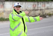 Neon sarı reflektörlü mont ve “polis” yazılı şapka giyen Down sendromlu Fırat Öztürk, yolda araçların yönünü elleriyle işaret ederek trafiği düzenliyor.