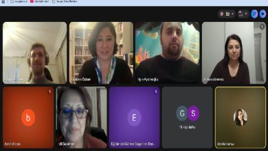 Görsel, bir Google Meet çevrimiçi toplantısının ekran görüntüsüdür. Koyu gri bir arayüz üzerinde katılımcıların yer aldığı sekiz kutucuk bulunmaktadır. Üst sırada Oğuz Akkaya, Gülden Özkan, Ilgın Aydınlıoğlu ve Nihan Dönmez'in kamera görüntüleri yan yana dizilmiştir. Alt sırada ise İdil Sayımer'in kamera görüntüsüyle birlikte; Beril Dilcan, Eğitimde Görme Engelliler Derneği ve Damla Karsu'nun isimlerinin veya profil simgelerinin bulunduğu paneller yer almaktadır. Ekranın en altında mikrofon, kamera ve görüşmeyi sonlandırma gibi standart toplantı kontrol butonları görülmektedir.