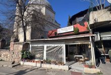 Arka planda kubbeli tarihi bir caminin yer aldığı ve önünde Edirne Bedensel Engellileri ve Ailelerini Koruma Yardımlaşma Derneği'nin binası ile sandalyelerin bulunduğu sakin bir sokak köşesi görülmektedir.